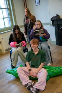 Four young actors in rehearsal with scripts