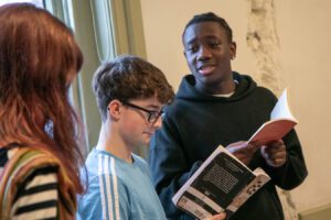 Three young actor holding scripts in rehearsal